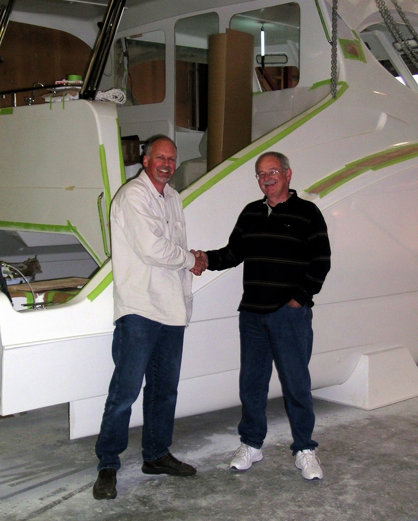 Grant Senior (Formula Cruisers) and Eric Knight (Logan Classic Boats) shaking hands in front of the last Prowler built by Logan’s. © Troy Woods